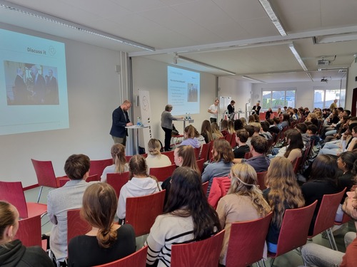 Politikerinnen und Politiker nehmen an einer Podiumsdiskussion vor Lernenden neutral Stellung zu politischen Themen