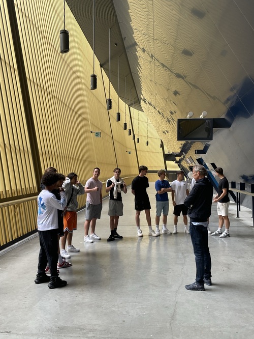 Auf dem Rundgang im Fussballstadium swissporarena hören die KV-Lernenden aufmerksam im Halbkreis zu